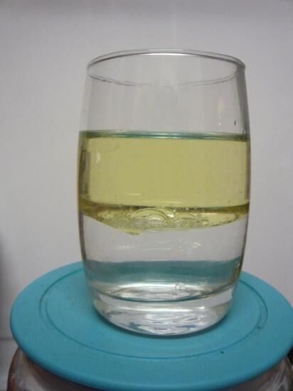 Oil remains on top of water in a glass.