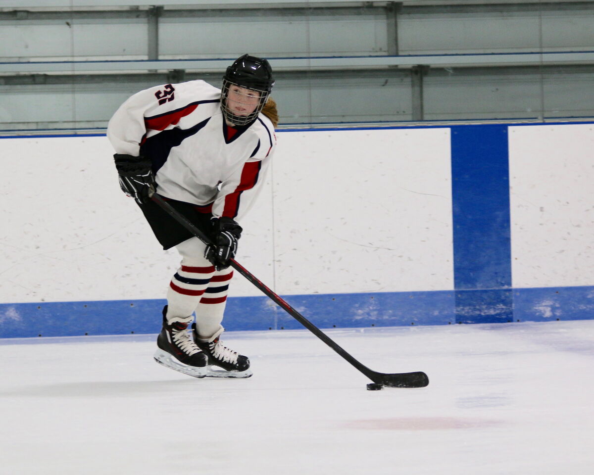 Une joueuse de hockey qui applique une force sur la rondelle pour changer sa trajectoire