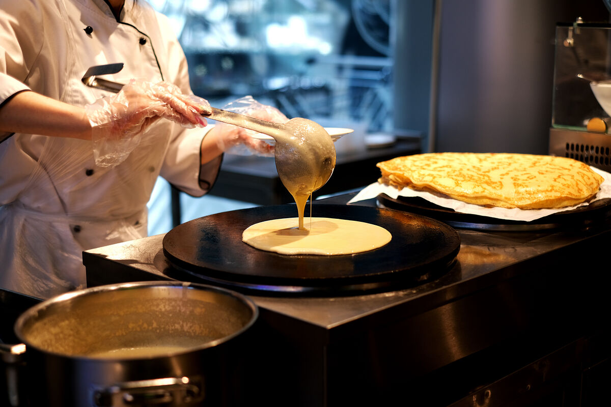 Cooking a crepe on a cast iron cooktop