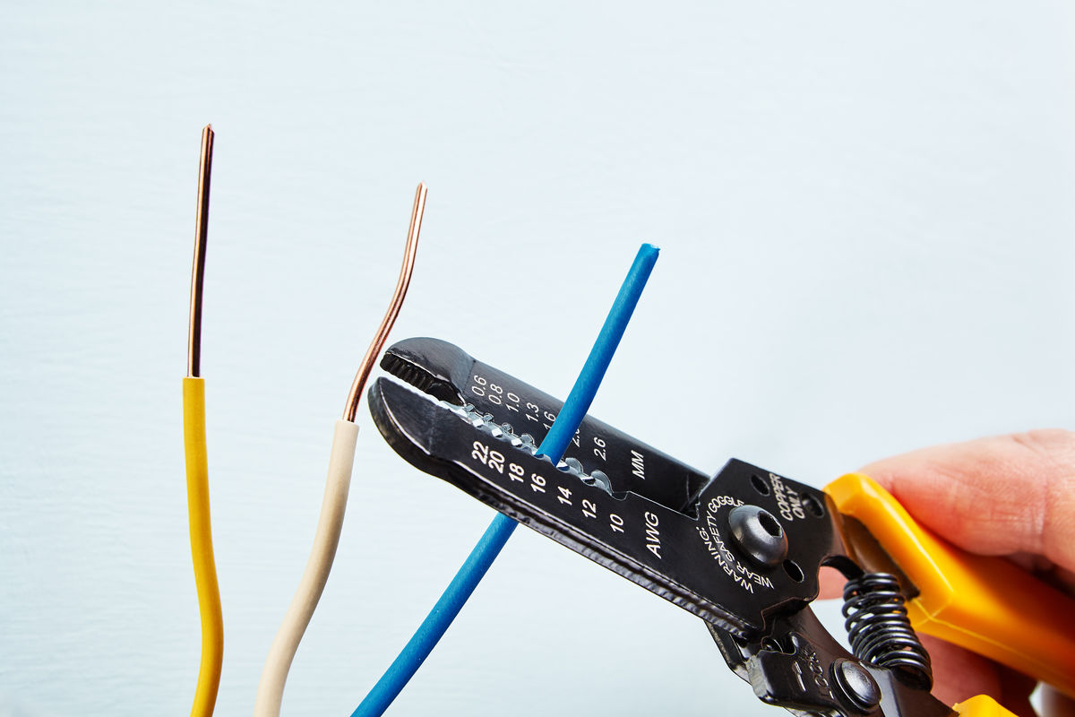 Stripping a copper wire using a wire stripper.