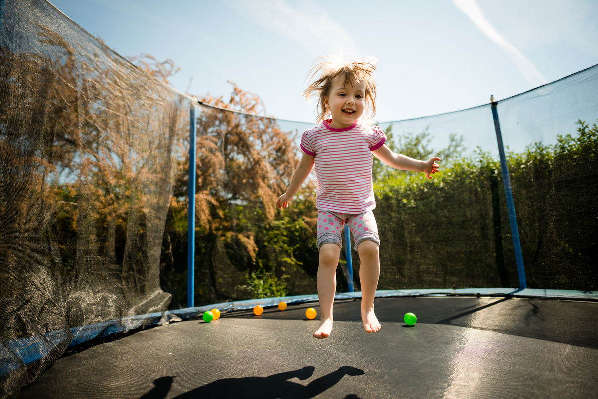 Une enfant saute sur un trampoline.