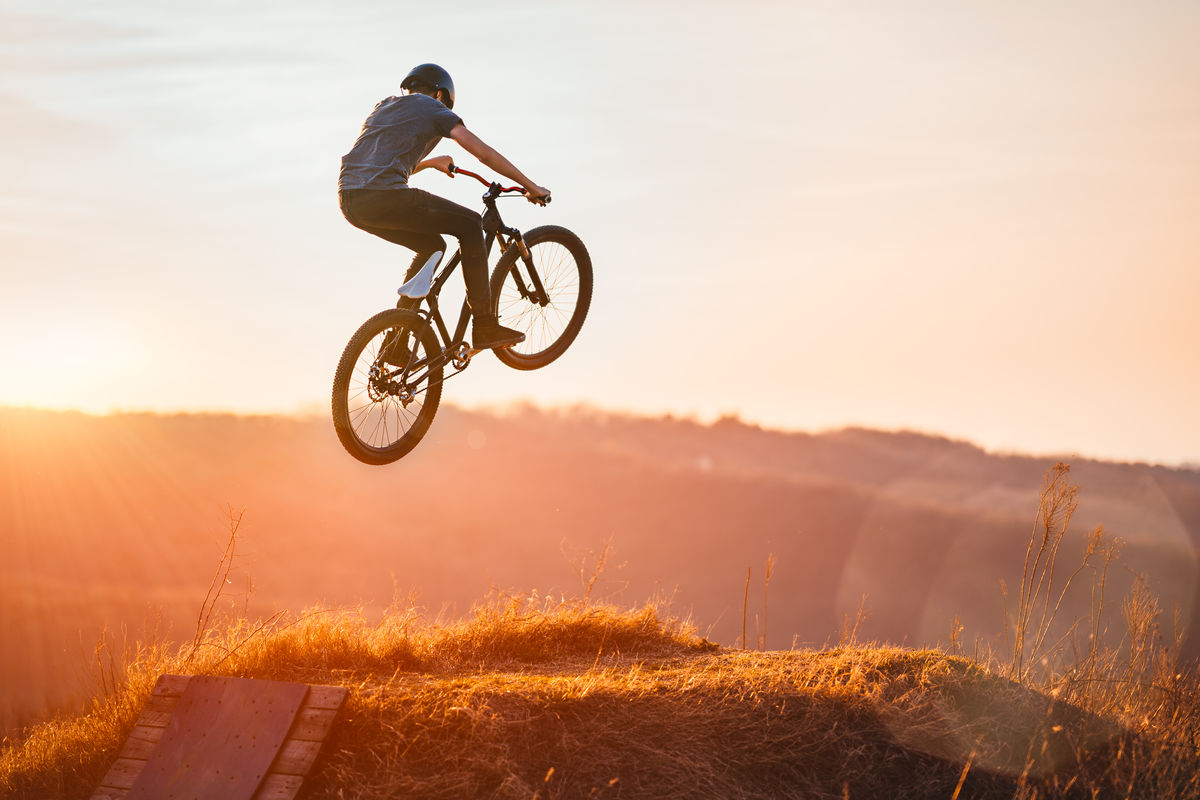 Une personne fait un saut à vélo à l’aide d’une rampe.