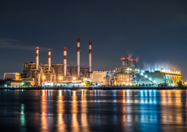 A coal-fired power station by the water at night.