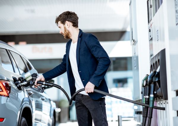 A person refueling a car at a gas station.