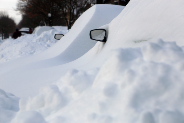 Voitures recouvertes de neige à Montréal après une tempête.