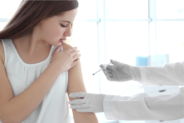 L’injection d’un contraceptif injectable dans le bras d’une jeune femme.