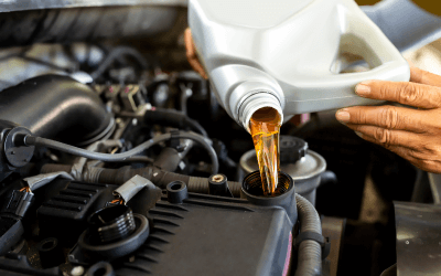 A person pouring motor oil.