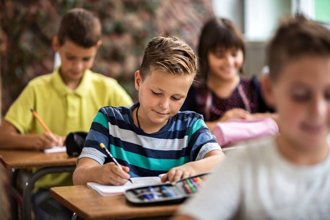 Quatre enfants travaillant à leur bureau.