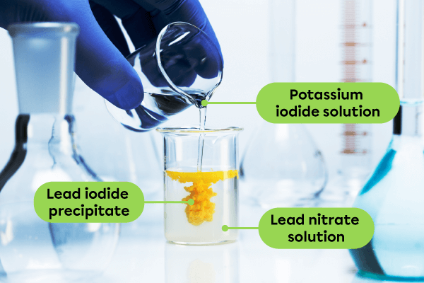 A photograph of a chemical change when two liquid substances come into contact to form a new yellow solid.