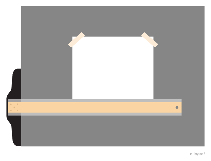 A photo of the sheet of white paper on the drawing board. The top edge of the T-square is aligned with the bottom edge of the sheet. Two pieces of tape are holding the sheet in place at the top corners.