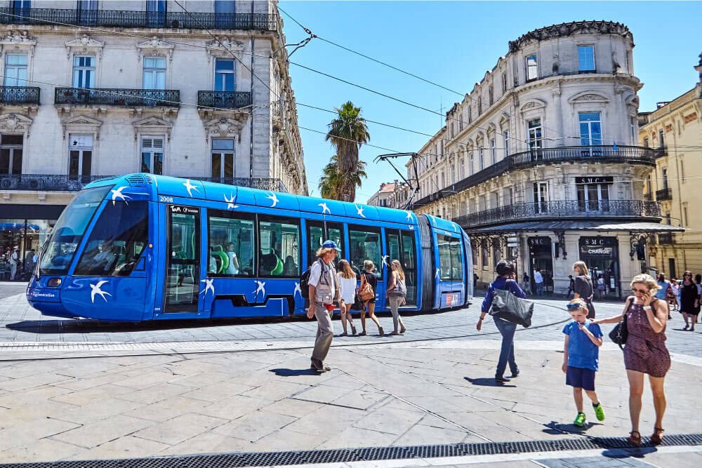 Photographie de piétons et d’un tramway.