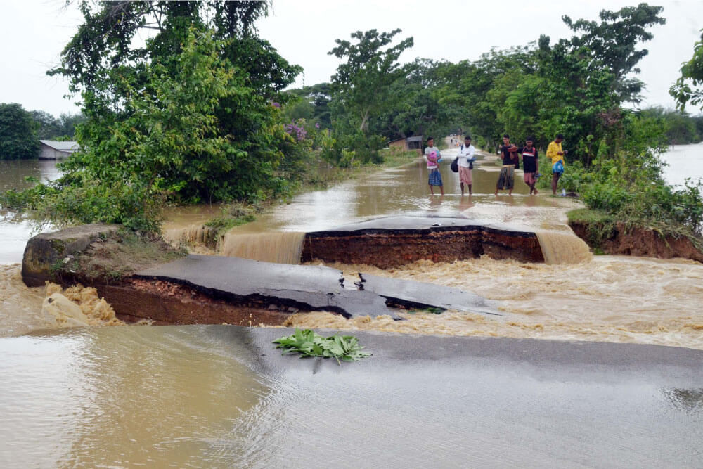 Photographie d’une route endommagée par une inondation en Inde.