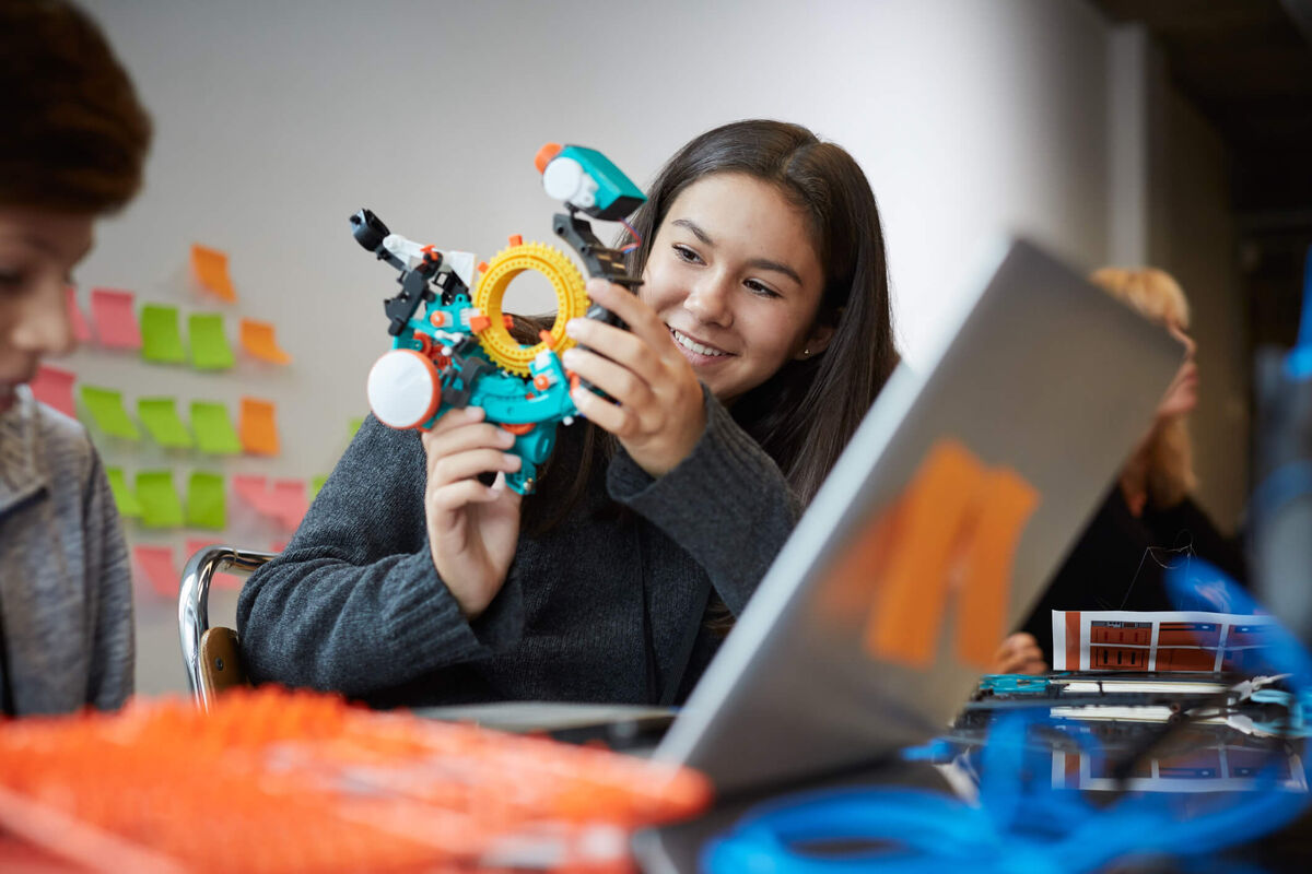 A student looking at a robot.