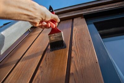Applying stain to wood planks. 