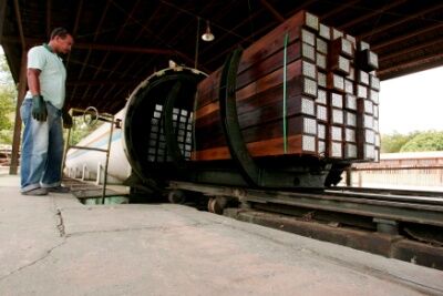 Pressure treating wooden beams in an autoclave. 