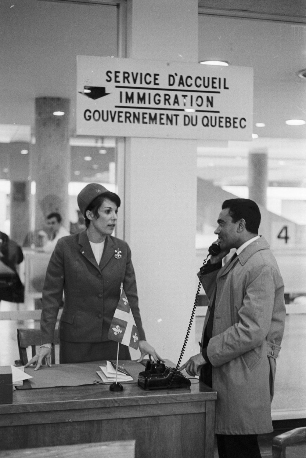 Photographie de deux personnes au service d’accueil pour l’immigration à Dorval.