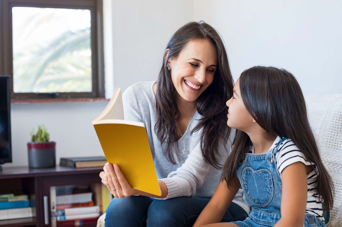 Une mère et sa fille regardant un livre.