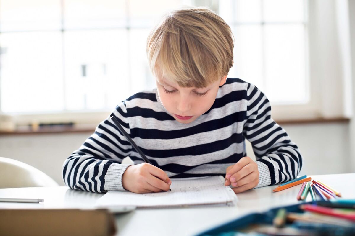 Un garçon faisant ses devoirs de façon autonome.