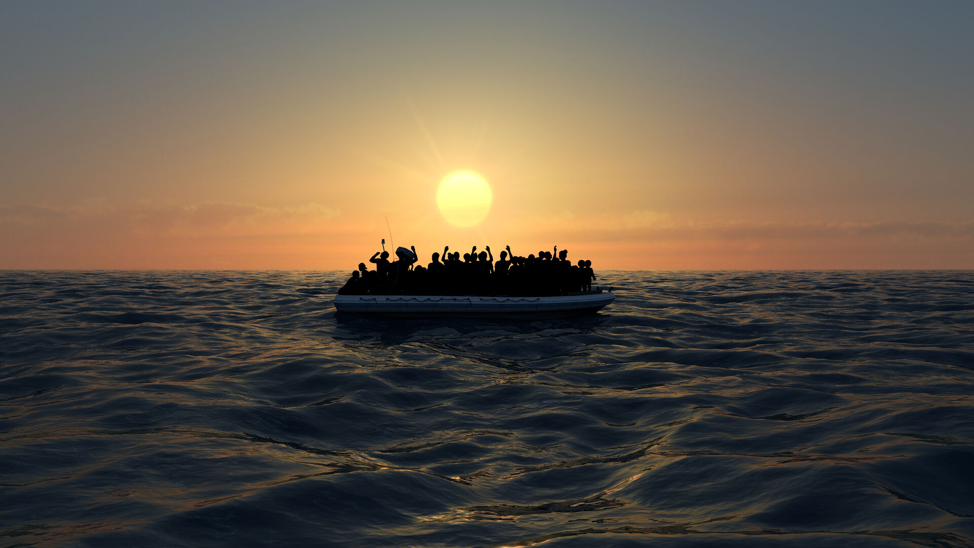 Des réfugiés sur un grand bateau en caoutchouc au milieu de la mer.
