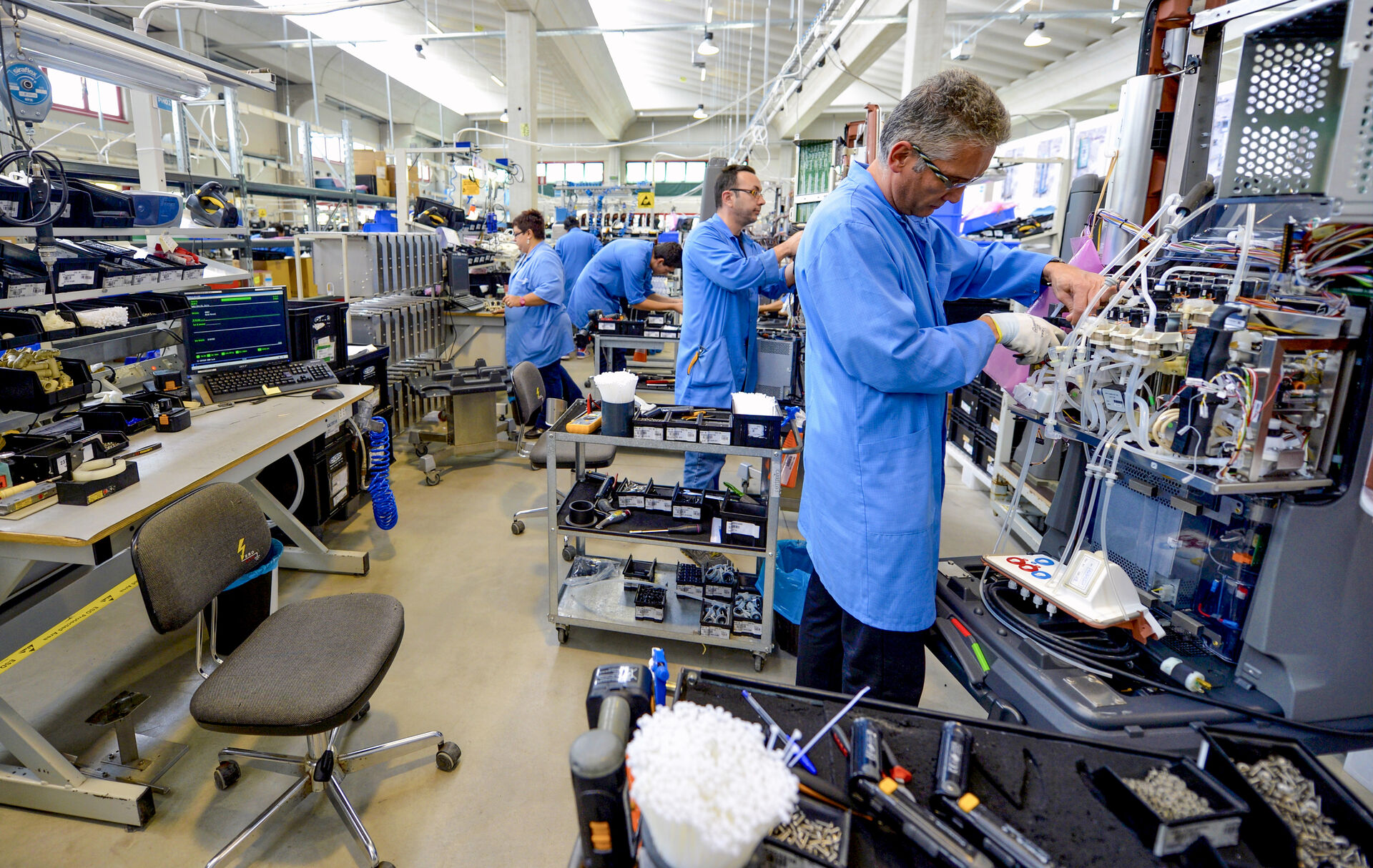 Picture of employees working on medical devices in a factory in Italy.