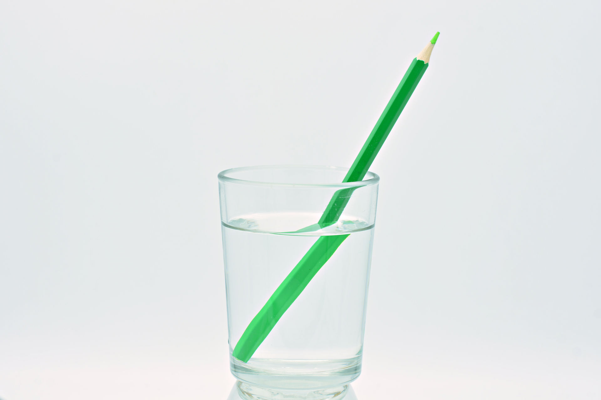 The deflection of light in water produces a distorted image of a pencil.