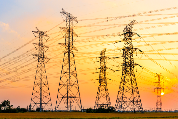 A landscape with high voltage lines supported by pylons.