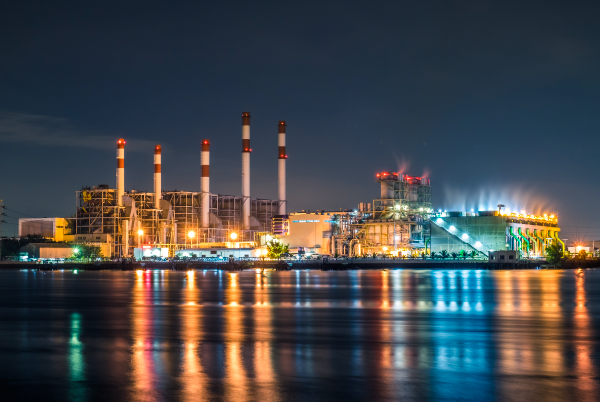 Une centrale thermique au bord d’un cours d’eau en soirée
