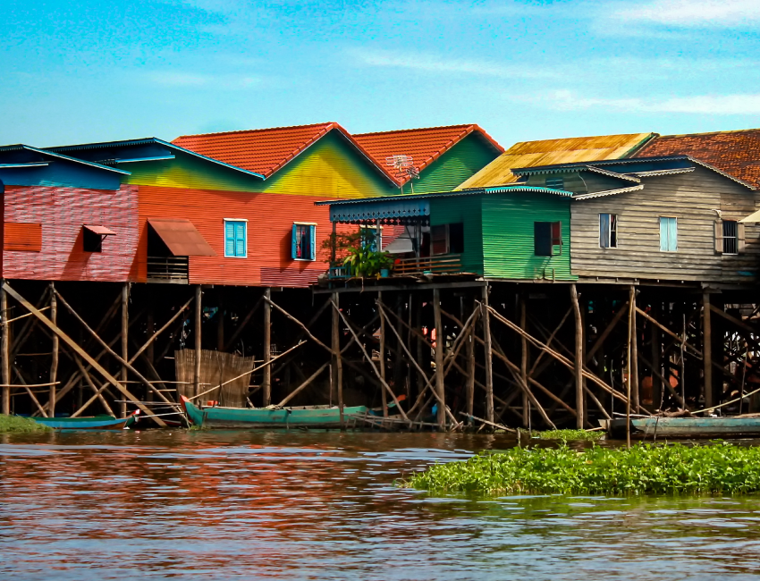 Photographie de maisons construites sur pilotis.