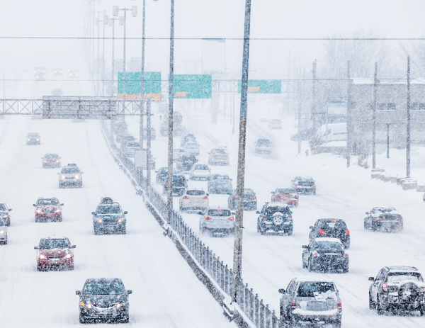 De la neige qui tombe du ciel sur des routes enneigées de Montréal.