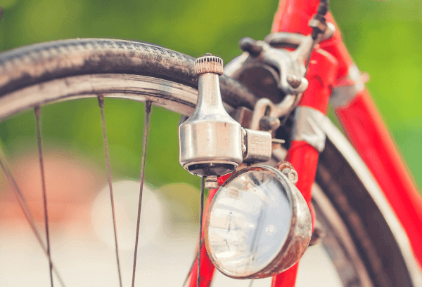 Une dynamo attachée à la roue avant d’un vélo.