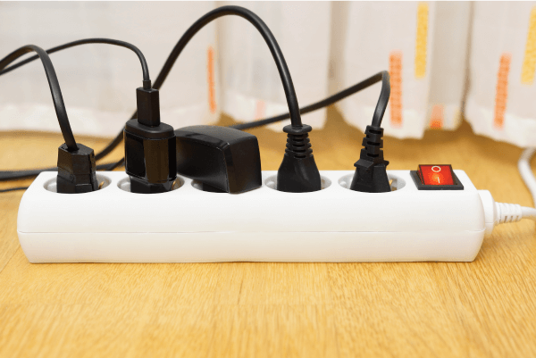 Une barre de surtension sur laquelle sont branchés plusieurs câbles d’alimentation.