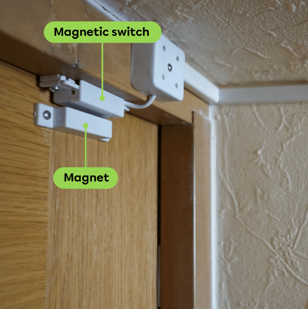 A magnetic switch installed on a door frame.