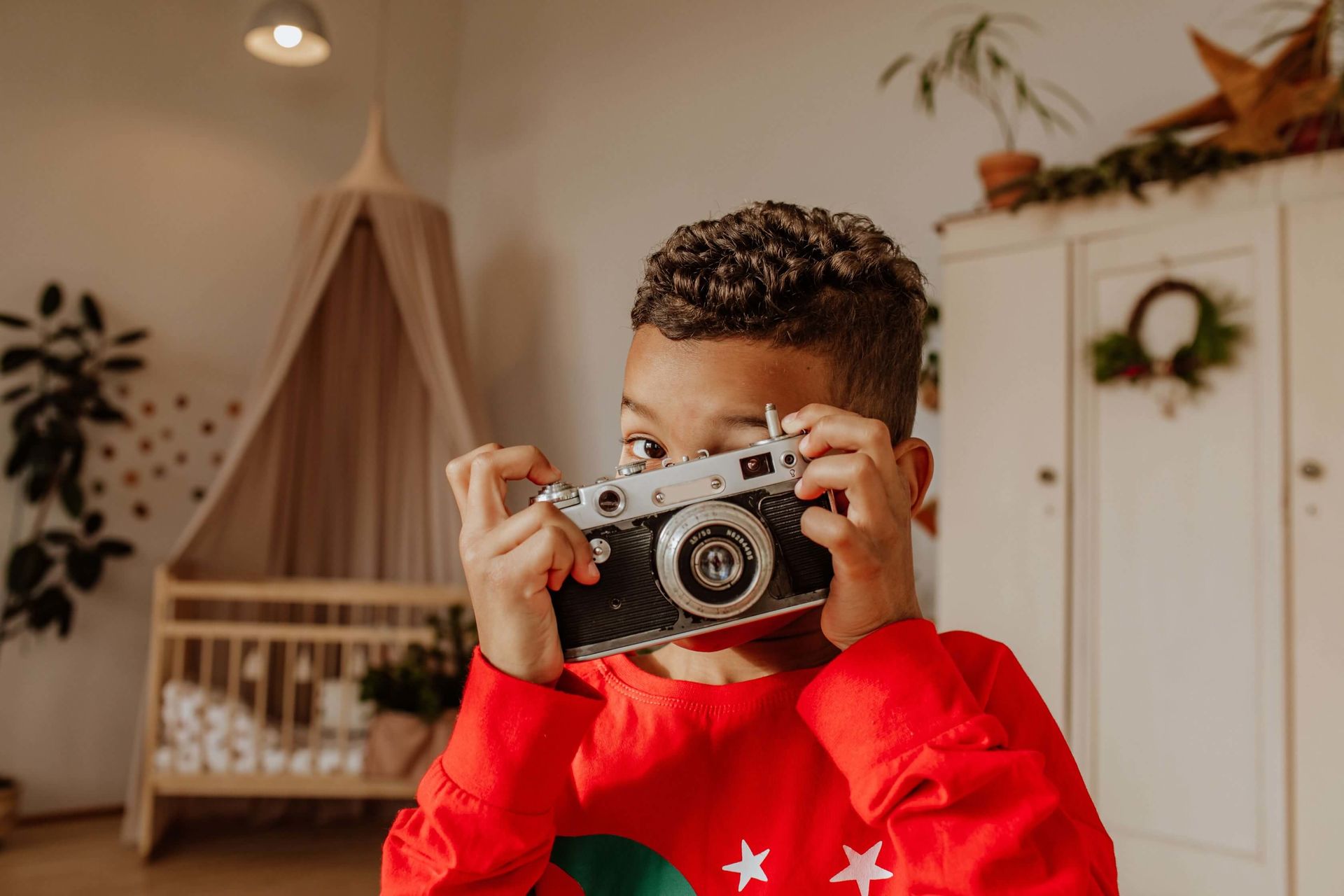boy takes a picture with a vintage camera