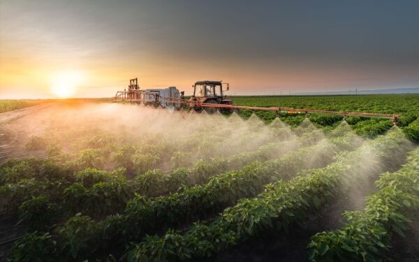 Un tracteur répand des pesticides dans un champ.