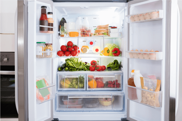 Intérieur d’un réfrigérateur avec la porte ouverte, révélant divers compartiments remplis de denrées alimentaires.