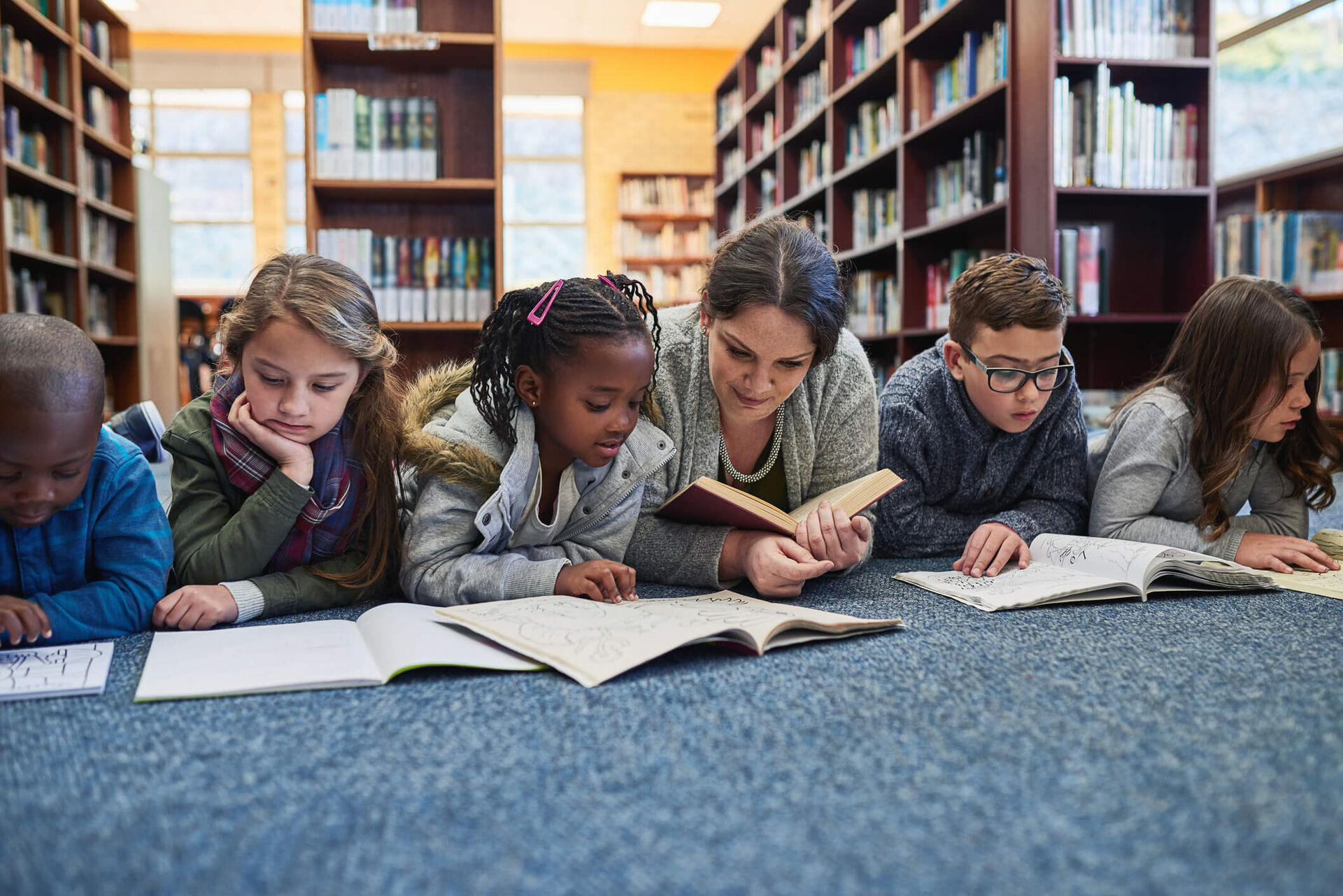 Une enseignante à la bibliothèque avec ses élèves.