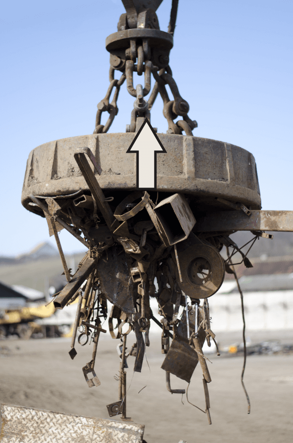 Image d’un aimant à ferraille, soit un électroaimant, qui applique une force d’attraction sur des pièces de ferraille. 